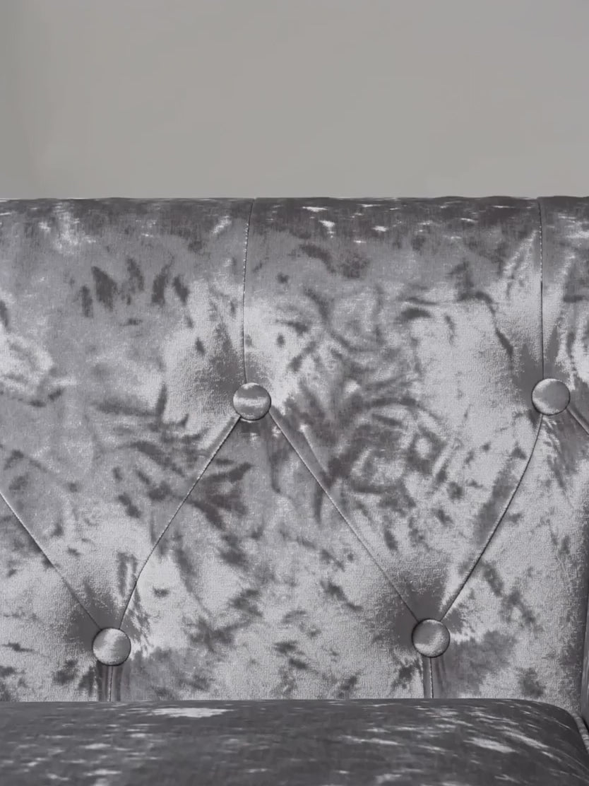 Close-up of The Big Lounge crushed velvet tufting, nailhead trim and solid wooden leg